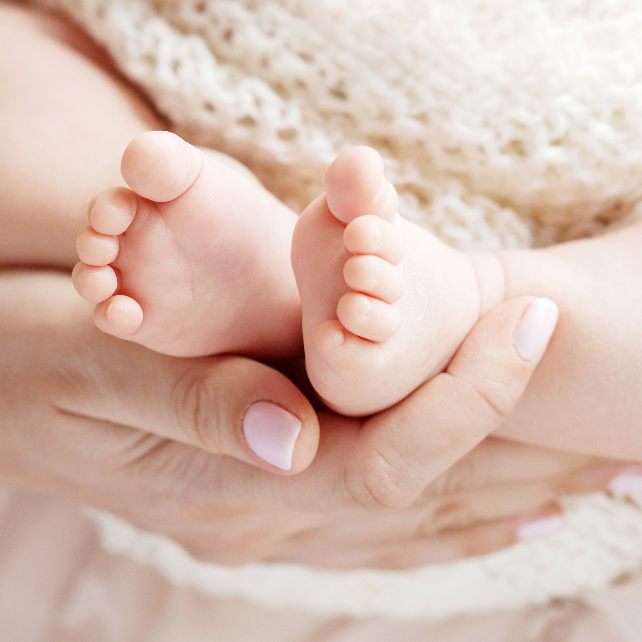 Rachel holding her newborns feet in professional photo